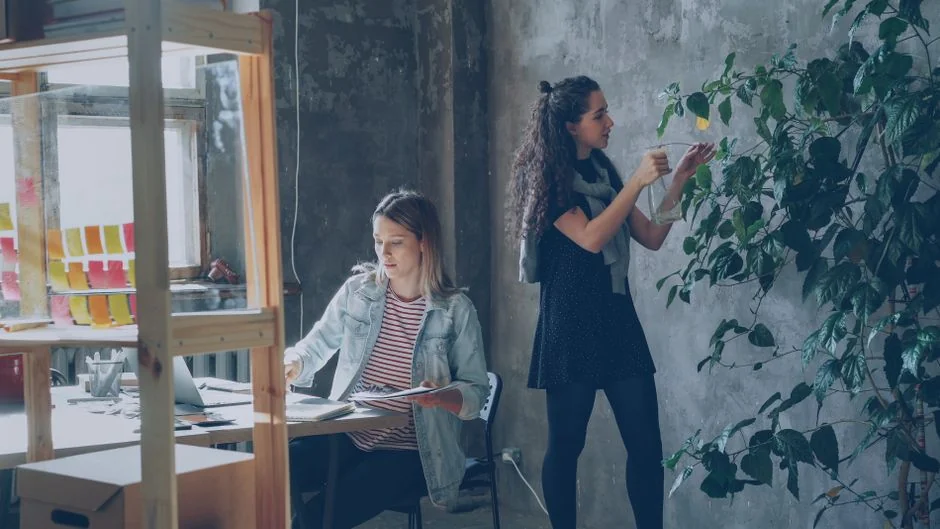 A person placing a sticky note onto a whiteboard that reads Social Media Marketing